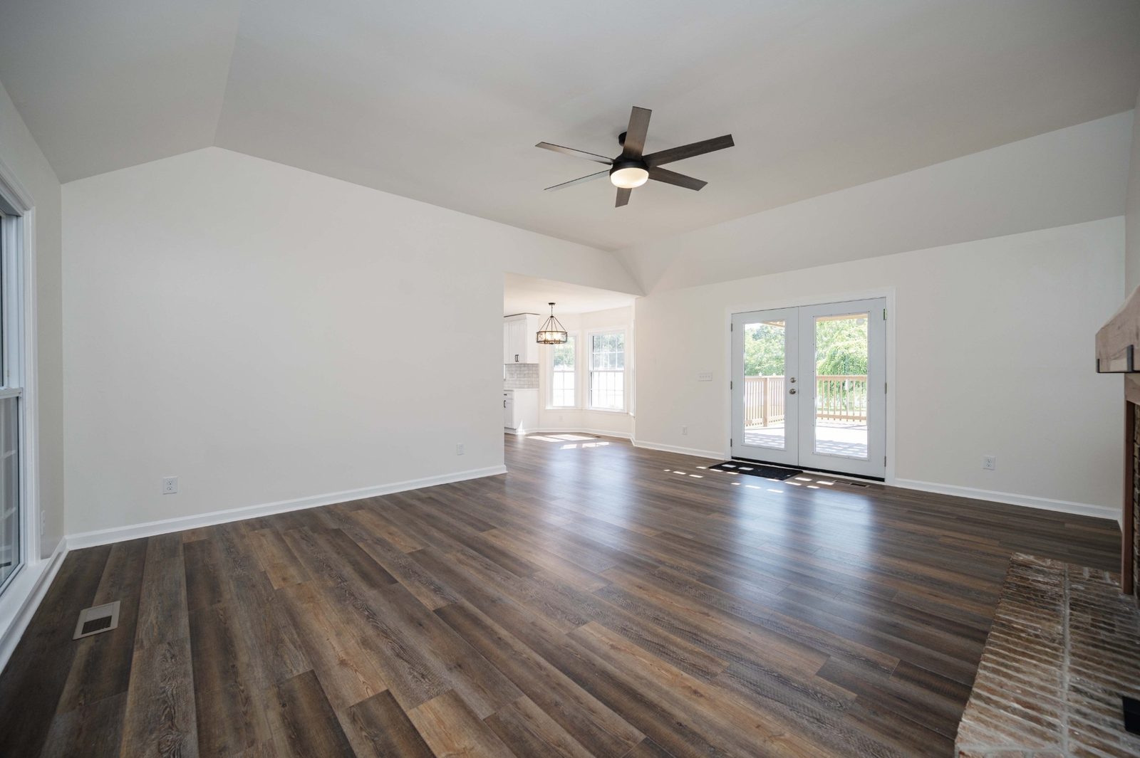 Living room with vaulted ceiling and wood look floors at 152 Greenbriar Circle