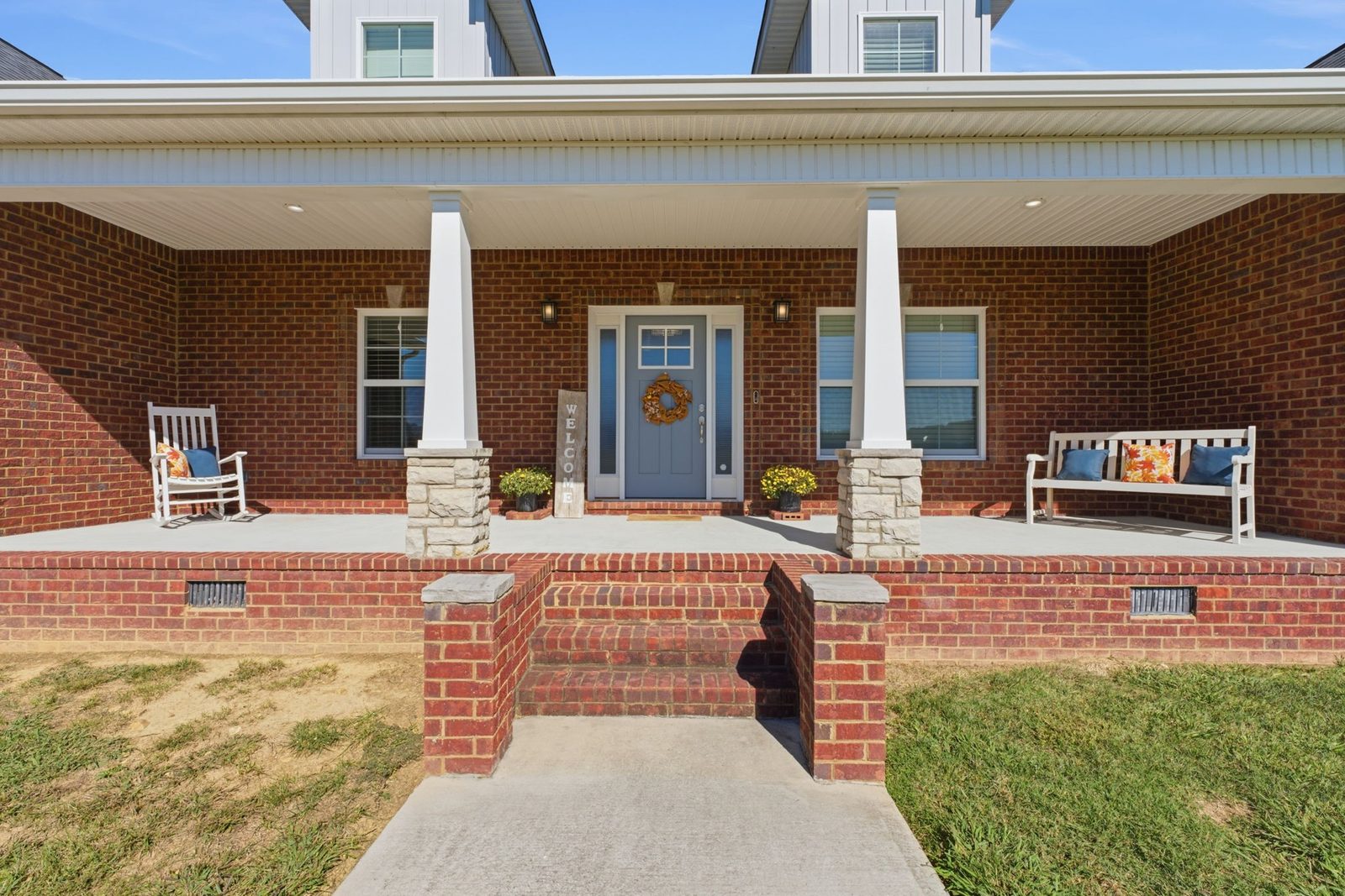 Covered front porch with brick columns and front door at 241 Roberts Creek Circle