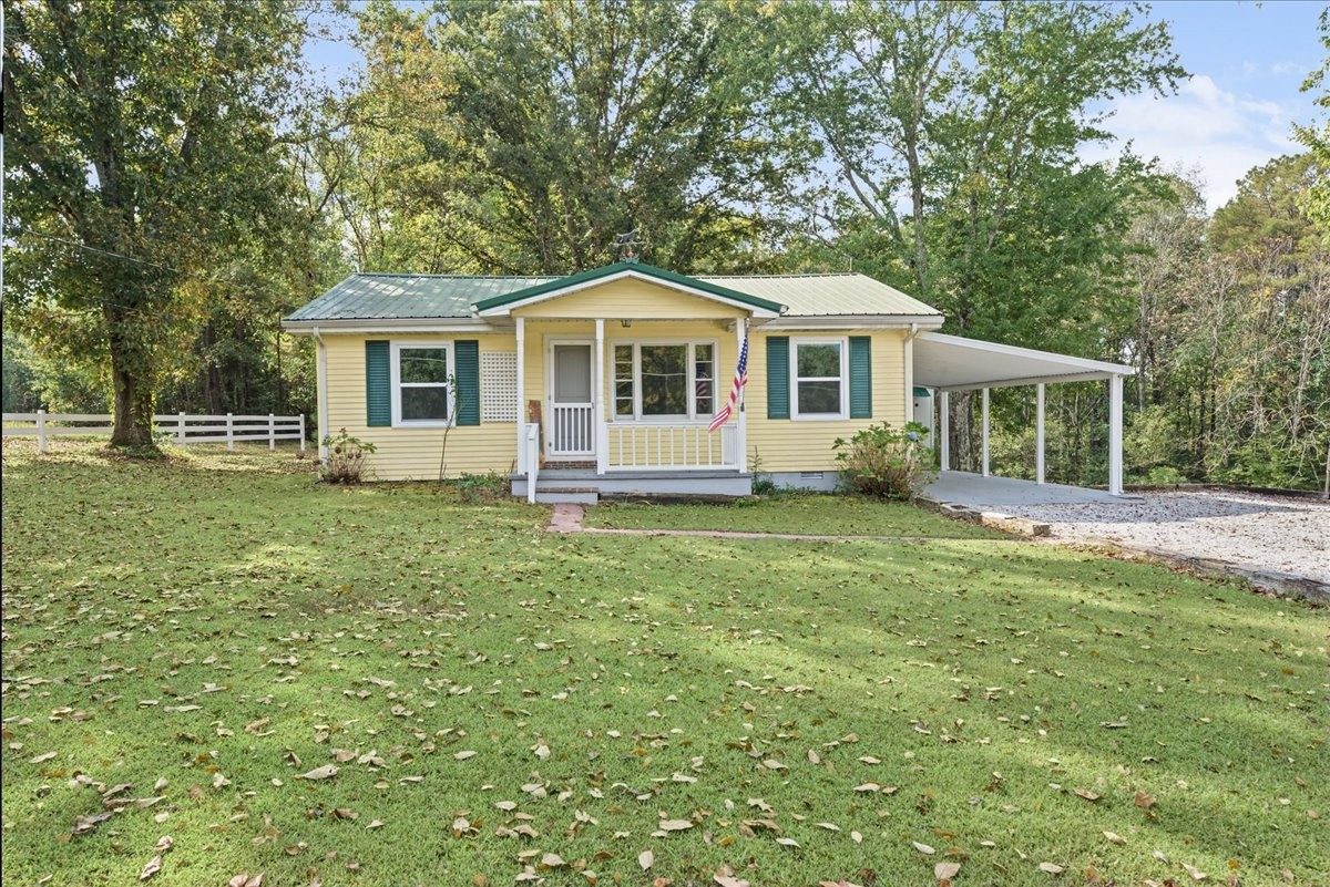 Front of the yellow cottage with a covered porch and carport at 3057 Mt View Road