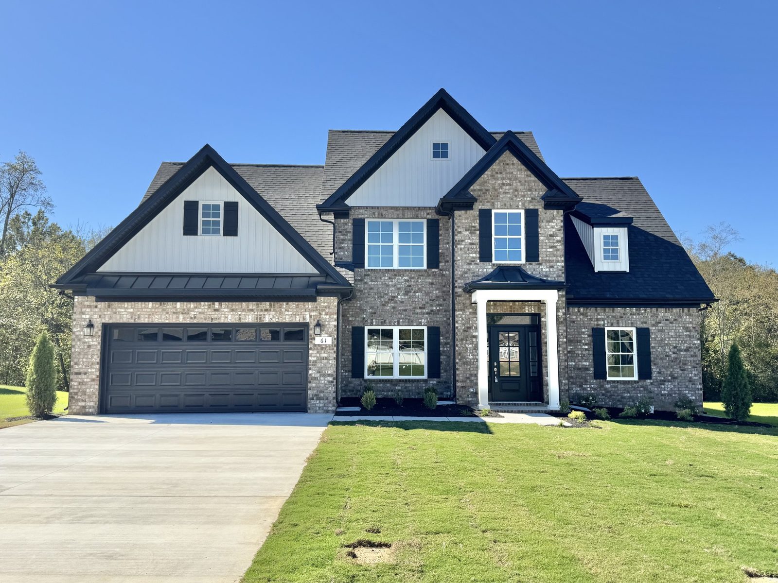 Front of the new two story home with stone and brick and a two car garage at 61 Spring House Drive