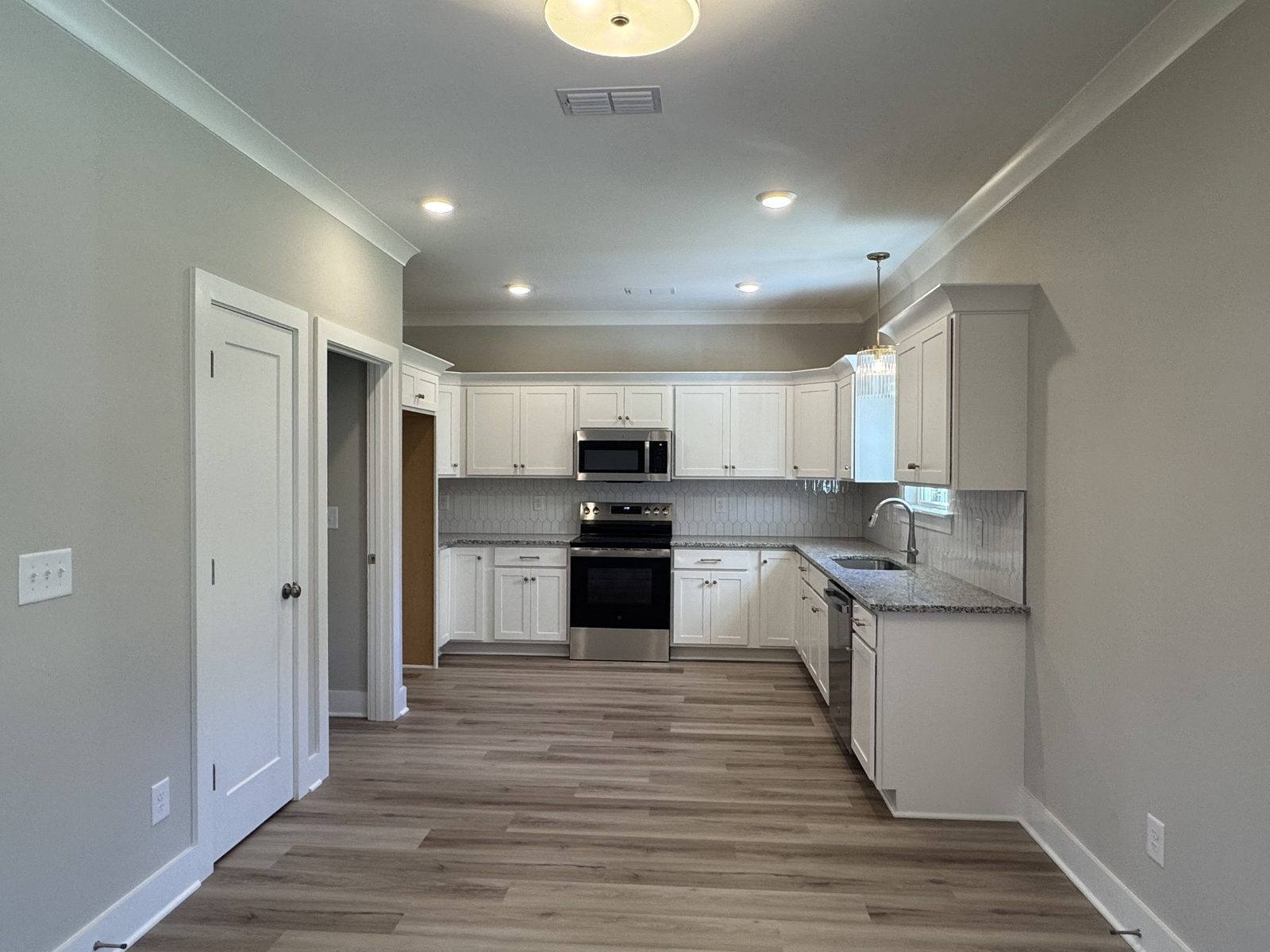 Kitchen with white cabinets and stainless appliances at 61 Spring House Drive