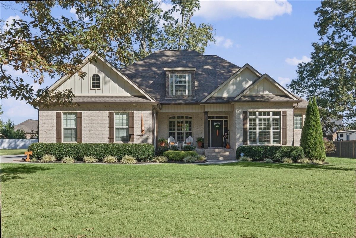 Front of the brick and stone home with landscaped beds at 612 Lexington Circle