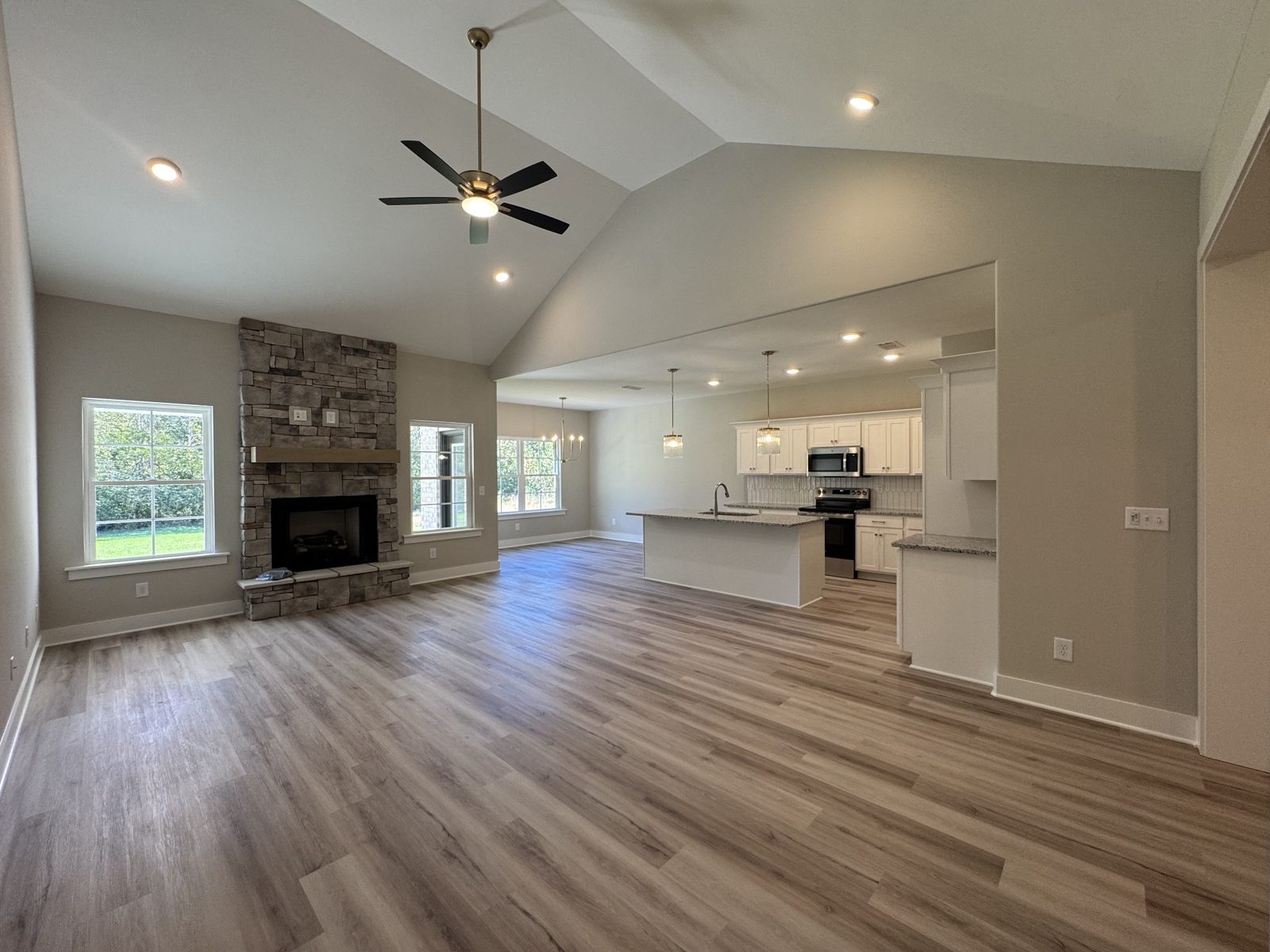 Living room with stone fireplace and ceiling fan at 79 Spring House Drive